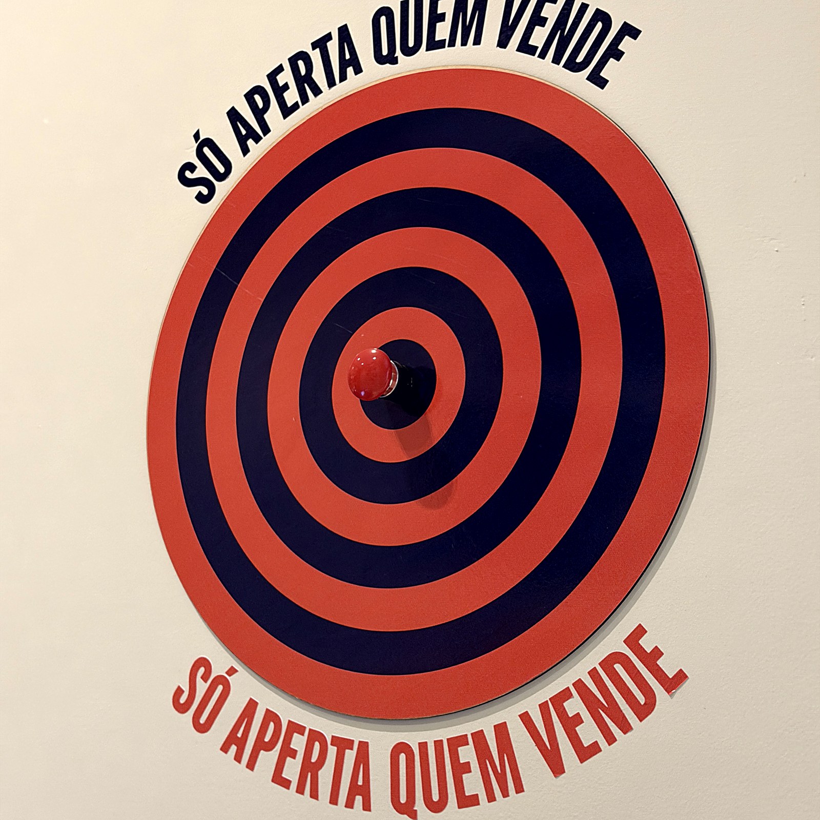 Painel com a frase Só aperta quem vende no escritório da Plugin
