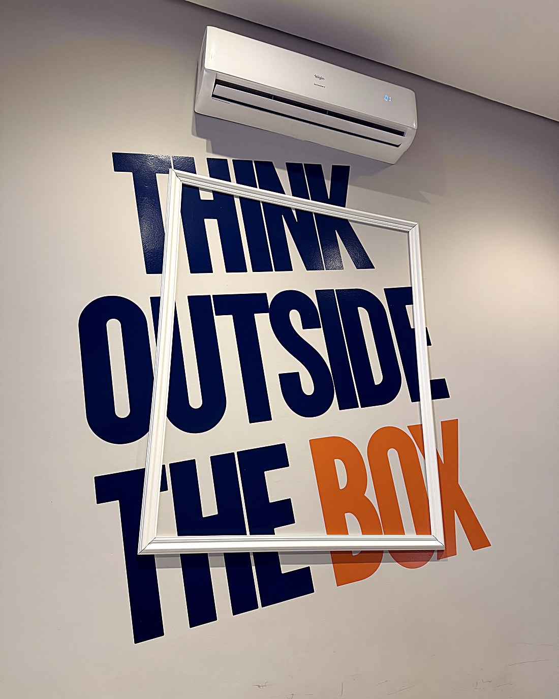 Parede com a frase Think Outside The Box no escritório da Plugin